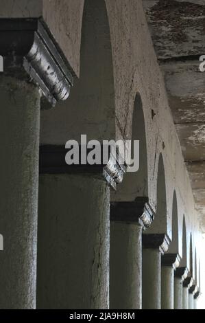 Industrielle Innenstadtkolonnade aus Betonsäulen, die eine Brücke hochhalten. Stockfoto