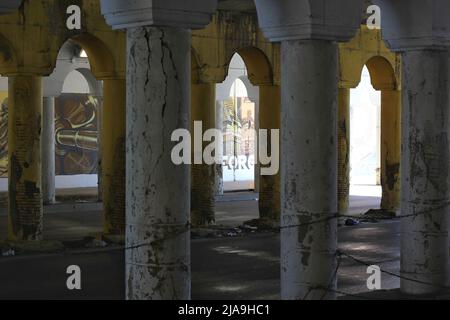 Industrielle Innenstadtkolonnade aus Betonsäulen, die eine Brücke hochhalten. Stockfoto