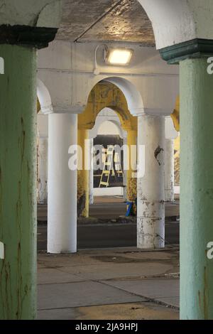 Industrielle Innenstadtkolonnade aus Betonsäulen, die eine Brücke hochhalten. Stockfoto