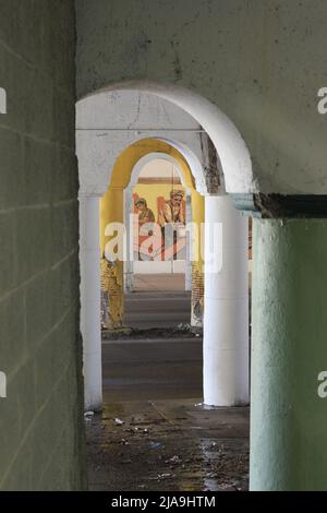 Industrielle Innenstadtkolonnade aus Betonsäulen, die eine Brücke hochhalten. Stockfoto