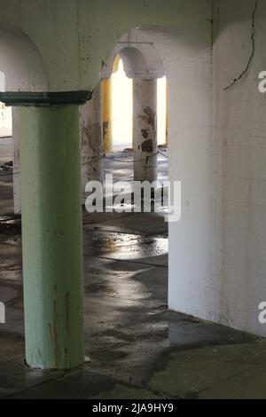 Industrielle Innenstadtkolonnade aus Betonsäulen, die eine Brücke hochhalten. Stockfoto