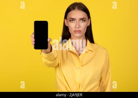 Traurige Dame mit leerem Smartphone-Bildschirm Stockfoto