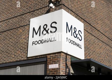 Ein Schild an der Außenseite von Marks and Spencer im Stadtzentrum von Basingstoke, auf dem eine M&S Foodhall angezeigt wird. England Stockfoto