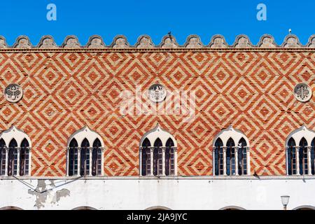 Antike Holzfenster mit länglichen Balkons auf einer bemalten Wand. Stockfoto