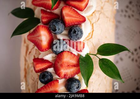 Nachtisch mit Meringue-Rolle und Beeren Stockfoto