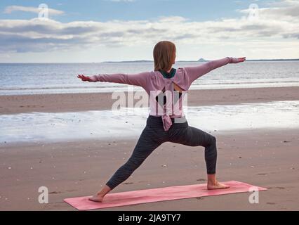 Portobello, Edinburgh Schottland, Großbritannien. 29. Mai 2022. Yoga-Übungen am Sandstrand. Temperatur ca. 9 Grad Celsius. Stockfoto