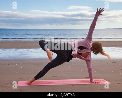 Portobello, Edinburgh Schottland, Großbritannien. 29. Mai 2022. Yoga-Übungen am Sandstrand. Temperatur ca. 9 Grad Celsius. Stockfoto