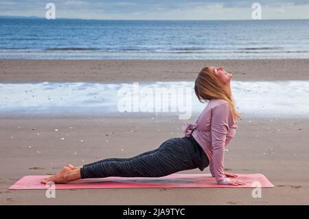 Portobello, Edinburgh Schottland, Großbritannien. 29. Mai 2022. Yoga-Übungen am Sandstrand. Temperatur ca. 9 Grad Celsius. Stockfoto