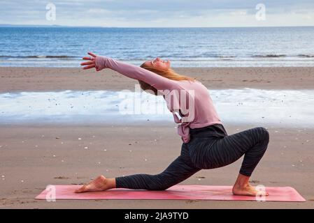 Portobello, Edinburgh Schottland, Großbritannien. 29. Mai 2022. Yoga-Übungen am Sandstrand. Temperatur ca. 9 Grad Celsius. Stockfoto