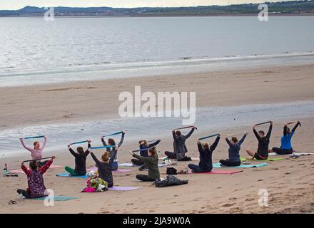 Portobello, Edinburgh Schottland, Großbritannien. 29. Mai 2022. Yoga-Übungen am Sandstrand. Temperatur ca. 9 Grad Celsius. Stockfoto