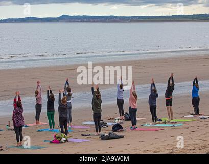 Portobello, Edinburgh Schottland, Großbritannien. 29. Mai 2022. Yoga-Übungen am Sandstrand. Temperatur ca. 9 Grad Celsius. Stockfoto