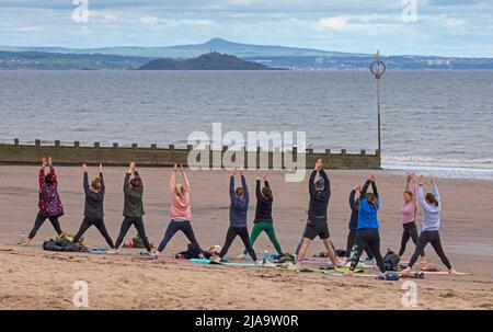 Portobello, Edinburgh Schottland, Großbritannien. 29. Mai 2022. Yoga-Übungen am Sandstrand. Temperatur ca. 9 Grad Celsius. Stockfoto