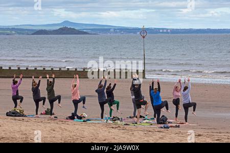 Portobello, Edinburgh Schottland, Großbritannien. 29. Mai 2022. Yoga-Übungen am Sandstrand. Temperatur ca. 9 Grad Celsius. Stockfoto