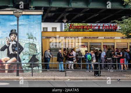 Konnopke's Imbiss, Schönhauser Allee 44B, Prenzlauer Berg,Berlin, Deutschland berühmte Currywurst steht unter dem U-Bahn-Viadukt am Eberswalder Hochbahnhof. Berlin. Max Konnopke und seine Frau Charlotte gründeten das Unternehmen 1930 mit einem Verkäufertablett an der Ecke Schönhauser und Danziger Straße. 1947, nach dem Zweiten Weltkrieg, kauften sie einen Wurstwagen und bauten 1960 am heutigen Standort eine Imbissbar und verkaufen seitdem das berühmteste Konnopke-Produkt, die Currywurst mit Ketchup. 1976 übernahm ihre Tochter Waltraud Ziervogel den Bus Stockfoto