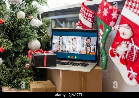 Virtuelle Weihnachtstag Hausfeier. Videokonferenzen, Videoanruf über Computer im Home Office. Online-Telefonkonferenz zum Öffnen von Geschenken für das Team. Stockfoto