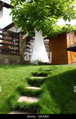 Hochzeitskomposition aus Schuhen, Blumenstrauß, Einladungsschreiben, Ringen, Parfüm in rosa Farben Stockfoto