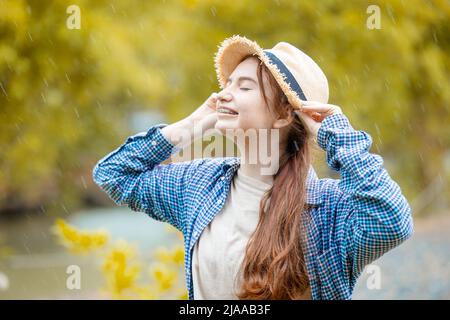 Nette junge schöne Brünette teen Mädchen glücklich lächelnd im Freien regnet Saison Stockfoto