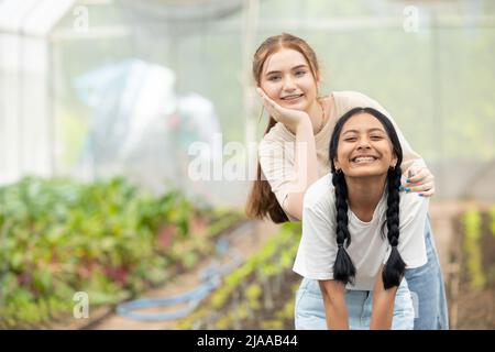 Zwei junge Teenager Mädchen glücklich lächelnd zusammen Freund mischen Rennen im Park Garten Stockfoto