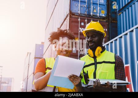 Mitarbeiter des Teams, die im Hafenfrachtzollbereich arbeiten, überprüfen Containerwaren für den Versand Stockfoto