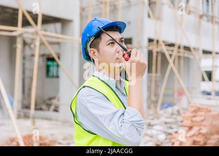 Arbeiter Vorarbeiter Ingenieur Baumeister arbeiten mit Funkbefehl in Hausbaustelle Sicherheitsprüfung. Stockfoto