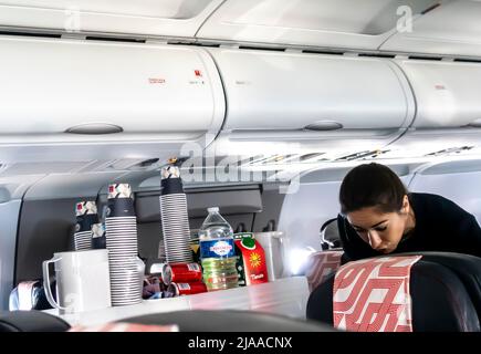 Flugbegleiter, der Passagieren in einer Flugzeugkabine des Typs Airbus A319 von Air France Mahlzeiten und Getränke serviert Stockfoto