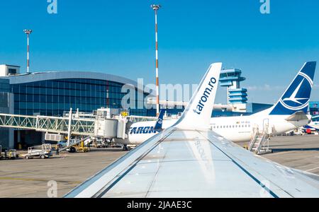 Flughafengebäude Bukarest, OTP, Otopeni, Rumänien mit Kontrollturm, tarom-Flugzeug am Flugsteig. Blick vom Flugzeugfenster von Tarom auf der Flügelseite Stockfoto