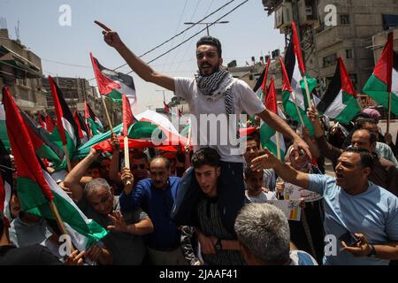 Khan Younis, Gaza. 29.. Mai 2022. Am Sonntag, den 29. Mai 2022, schwenken Palästinenser während eines Protestes über die Spannungen in der Al-Aqsa Moschee in Khan Younis im südlichen Gazastreifen palästinensische Flaggen. Das erinnert an die Vereinigung der Stadt, nachdem Israel 1967 das östliche Damaskus-Tor annektiert hatte. Jerusalem macht sich bereit für einen umstrittenen „flaggenmarsch“ von Israelis, der Warnungen vor einer neuen Eskalation seitens der palästinensischen Fraktionen ausgelöst hat. Foto von Ismael Mohamad/UPI Credit: UPI/Alamy Live News Stockfoto