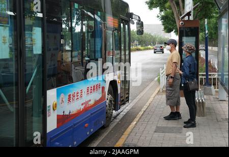 Peking, China. 29.. Mai 2022. Menschen sind dabei, an einer Bushaltestelle im Bezirk Shunyi in Peking, der Hauptstadt Chinas, in einen Bus zu steigen, 29. Mai 2022. In Peking wurde COVID-19 von Freitag bis Sonntag um 3 Uhr nicht von der Gemeinde in der Stadt übertragen, sagte ein Beamter auf einer Pressekonferenz am Sonntag. Die chinesische Hauptstadt meldete von Ende Samstag bis Sonntag um 3 Uhr sieben neue lokal übertragene COVID-19-Infektionen, die alle zu den zur Beobachtung unter Quarantäne gestellten gehörten, sagte Liu Xiaofeng, stellvertretender Direktor des Pekinger Zentrums für die Prävention und Kontrolle von Krankheiten. Quelle: Ren Chao/Xinhua/Alamy Live News Stockfoto