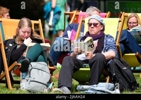 Hay Festival, Hay on Wye, Wales, Großbritannien – Sonntag, 29.. Mai 2022 – die Besucher von Hay können sich am vierten Tag des diesjährigen Hay Festivals zwischen den Veranstaltungen auf den Festivalrasen ein wenig Zeit zum Lesen von Büchern gönnen – das ist das erste Mal, dass die Veranstaltung seit 2019 persönlich stattfindet. Das Hay Festival läuft bis Sonntag, den 5.. Juni 2022. Foto Steven May / Alamy Live News Stockfoto