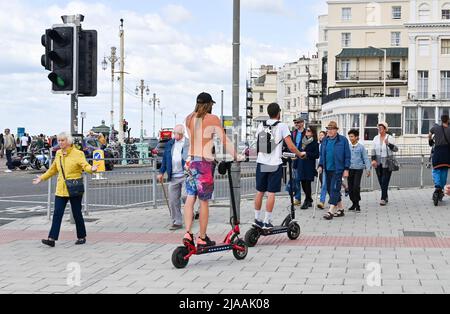 Brighton UK 29. May 2022 - Besucher auf E-Scootern genießen die Sonne an der Küste von Brighton, da für Großbritannien in den nächsten Tagen kühleres Wetter prognostiziert wird : Credit Simon Dack / Alamy Live News Stockfoto