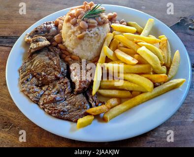 Gericht mit Reis, Bohnen, pommes Frites und Fleisch Stockfoto