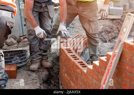 Maurer arbeiten an einer gebogenen Wand Stockfoto