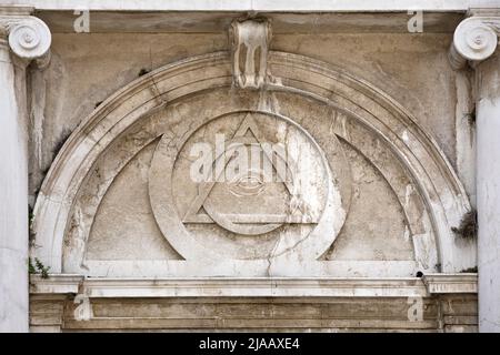 Alte Architektur mit, alle sehenden Augenreliefs, Maurersymbol über dem Eingang zur saint magdeleine Kirche in Vience Italien. Stockfoto