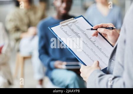 Nahaufnahme eines männlichen Lehrers, der im Büro Englischunterricht erteilt und die Zwischenablage mit Grammatiknotizen hält, Platz zum Kopieren Stockfoto