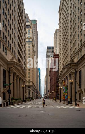 S La Salle Street, an der Kreuzung W Jackson Boulevard, Chicago, IL. Ein Mann überquert den Fußgängerüberweg im Hintergrund hoher Gebäude. USA Stockfoto