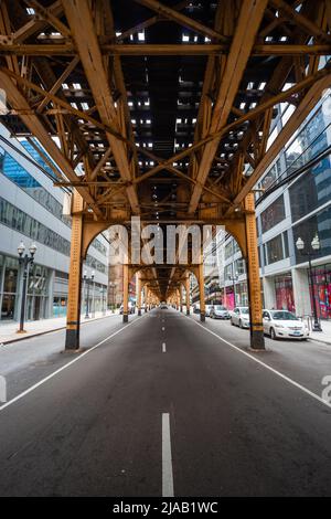 Erhöhte Bahngleise auf einer Straße in Chicago, die die Strecke über der Straße zeigt, auf der das Schnellnahverkehrssystem Chicago L läuft. IL, USA. Unter dem El Stockfoto