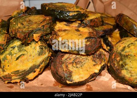 Saheena, die in Trinidad, Westindien, hergestellt wird. Saheena wird aus Dasheen-Busch-Bhagi oder Spinat hergestellt, in gespaltenen Erbsen-Pulver zerschlagen und frittiert. Stockfoto