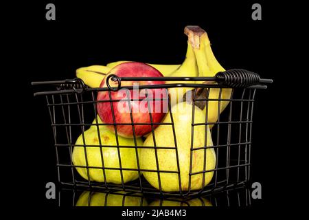 Zwei saftige, leuchtend gelbe Birnen, ein roter Apfel und ein Haufen Bananen in einem Metallkorb, aus nächster Nähe, isoliert auf schwarzem Hintergrund. Stockfoto