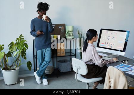 Porträt eines vielfältigen Teams, das in einem Firmenbüro arbeitet und arbeitet, Fokus auf schwarzen jungen Mann, der in der Pause Kaffee trinkt, Kopierfläche Stockfoto