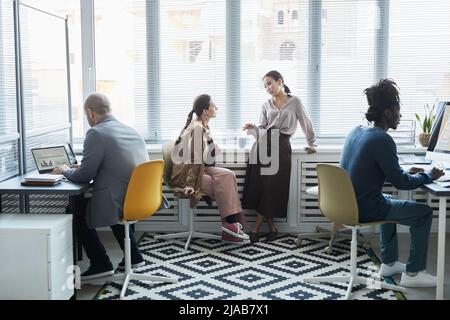 Ausgewogene Weitwinkelansicht auf verschiedene Gruppen von Personen, die im Büro des Unternehmens arbeiten Stockfoto