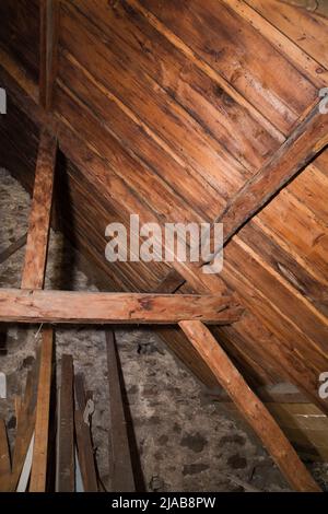 Freiliegende Holzbalken, Sparren und Dachbretter im Dachgeschoss des alten, ca. 1760 im kanadischen Cottage-Stil gebauten Feldsteinhauses. Stockfoto