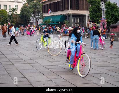 Jakarta, Indonesien - 15. Mai 2022: Menschenmassen, die Fahrräder spielen, um das Fatahillah Museum herum. Altstadt, Jakarta, Indonesien. Stockfoto