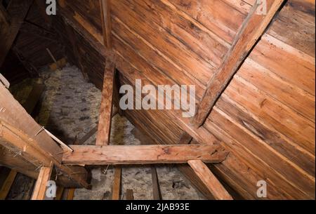 Freiliegende Holzbalken, Sparren und Dachbretter im Dachgeschoss des alten, ca. 1760 im kanadischen Cottage-Stil gebauten Feldsteinhauses. Stockfoto