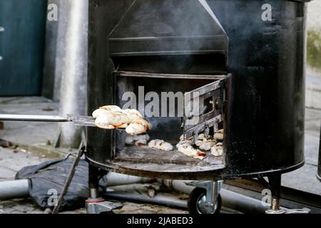 Brot mit Chorizo, ein traditionelles Rezept, das in einem Holzofen zubereitet wird. Traditionelles Essen auf traditionellen Veranstaltungen oder Messen. Straßenverkäufer. Stockfoto