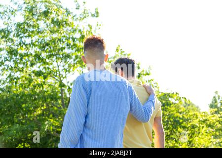 Junge schwule Paar genießen einen Spaziergang im Freien im Park. LGBT- und Beziehungskonzept. Stockfoto