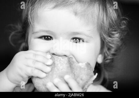 Baby essen Brötchen Brot. Nahaufnahme. Nettes Kleinkind Kind essen Sandwich, Selbstfütterung Konzept. Stockfoto