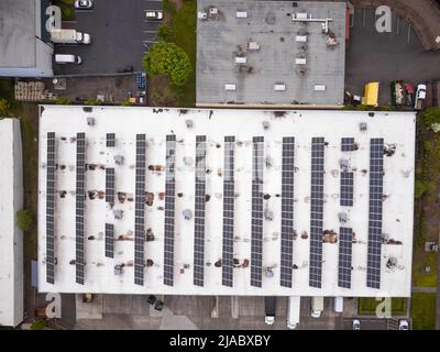 Schießen von einer Drohne. Ein großes Dach eines Industriegebäudes, Parkplatz, viele Autos auf der Autobahn. Grüner Rasen. Karte, Planung, Topographie, Infrastruktur Stockfoto