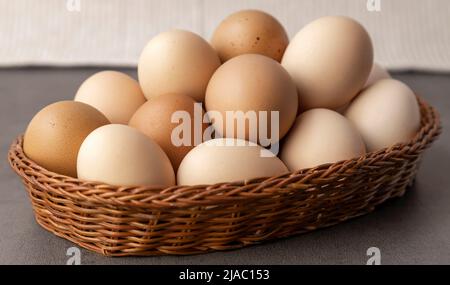 Hühnereier auf dem Bauernhof. Viele Eier in einem Korbkorb aus der Nähe. Stockfoto
