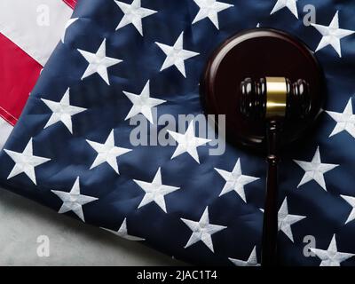 Hölzerner Richtergavel auf dem Hintergrund der amerikanischen Flagge Close-Up. Recht, Gerechtigkeit, Gleichheit des Rechts, Gerichtssaal, Unschuldsvermutung, Verfassung Stockfoto