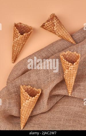 Vier Eiswaffelkegel und Quappen-Stoff. Draufsicht. Flache Lay-Komposition. Stockfoto